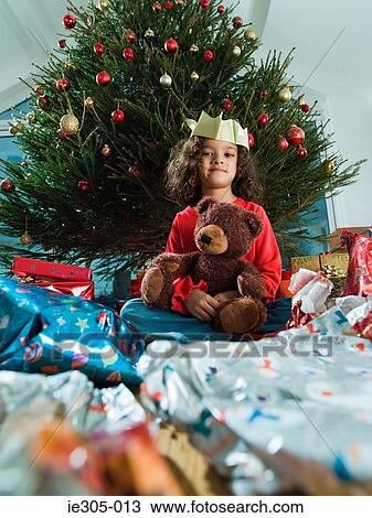 Stock Image - Girl with a teddy bear at christmas. Fotosearch