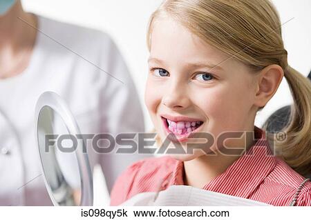 Stock Image - Girl with disclosing tablet on her teeth. Fotosearch