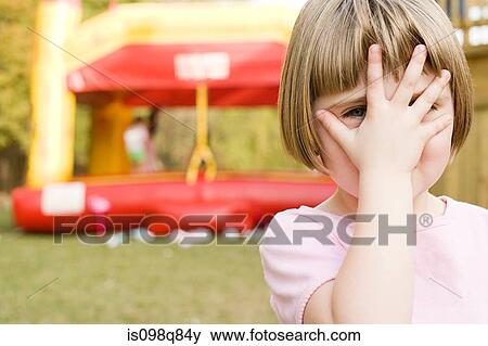 Stock Photo - Girl with hand in front of face. Fotosearch