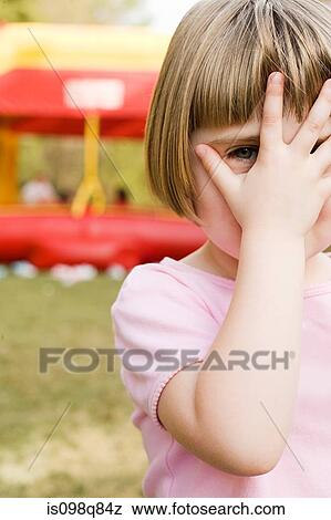 Stock Photo - Girl with hand in front of face. Fotosearch