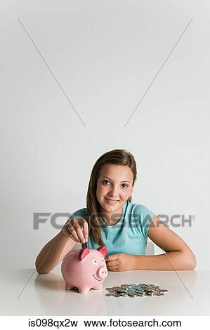 Stock Photo - Girl with piggy bank and coins. Fotosearch