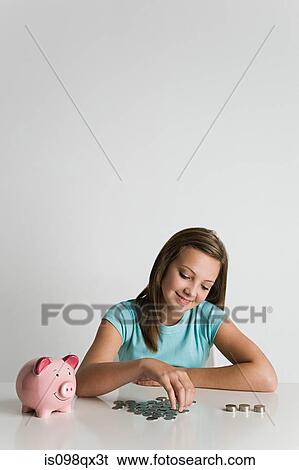Girl with piggy bank and coins View Large Photo Image Stock Photograph - Girl with piggy bank and coins. Fotosearch
