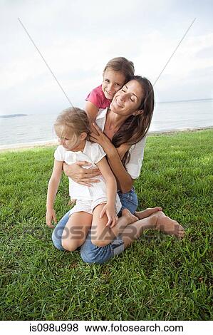Girls and mother hugging outdoors View Large Photo Image Stock Photo - Girls and mother hugging outdoors. Fotosearch