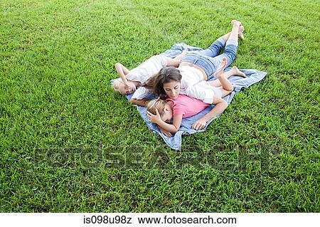 Girls and mother lying on grass View Large Photo Image Stock Photo - Girls and mother lying on grass. Fotosearch