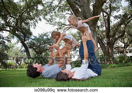 Girls balancing on feet of parents View Large Photo Image Stock Photography - Girls balancing on feet of parents. Fotosearch