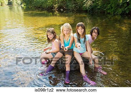 Girls in a river with rocks View Large Photo Image Stock Image - Girls in a river with rocks. Fotosearch