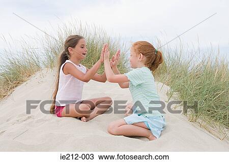 Stock Image - Girls playing pat a cake. Fotosearch