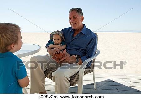 Grandfather sitting with two grandsons View Large Photo Image Stock Image - Grandfather sitting with two grandsons. Fotosearch