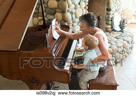 Stock Image - Grandmother and grandson playing the piano. Fotosearch