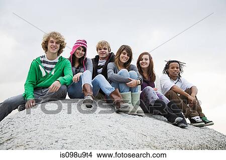 Group of friends sitting on boulder View Large Photo Image Picture - Group of friends sitting on boulder. Fotosearch