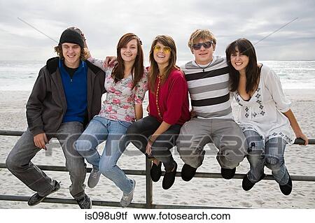 Group of friends sitting on railings View Large Photo Image Stock Image - Group of friends sitting on railings. Fotosearch