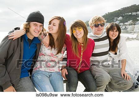 Group of friends sitting on railings View Large Photo Image Stock Photo - Group of friends sitting on railings. Fotosearch