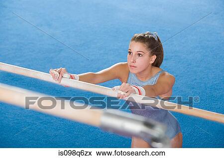 Gymanst holding onto uneven parallel bars View Large Photo Image Stock Photo - Gymanst holding onto uneven parallel bars. Fotosearch