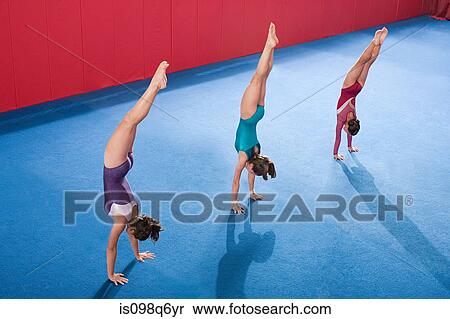 Gymnasts in a row doing handstands View Large Photo Image Stock Photography - Gymnasts in a row doing handstands. Fotosearch