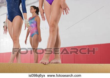 Gymnasts standing on a balance beam View Large Photo Image Stock Photo - Gymnasts standing on a balance beam. Fotosearch