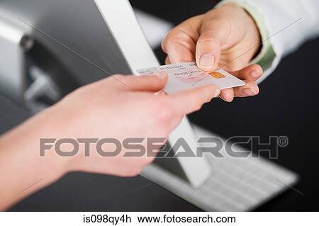 Stock Image - Handing over credit card. Fotosearch