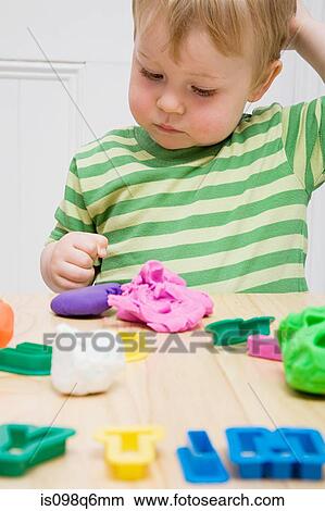 Little boy with modelling clay View Large Photo Image Picture - Little boy with modelling clay. Fotosearch