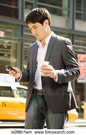 Male office worker using a cell phone on street View Large Photo Image Picture - Male office worker using a cell phone on street. Fotosearch