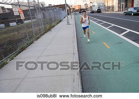 Stock Image - Male runner on urban street. Fotosearch
