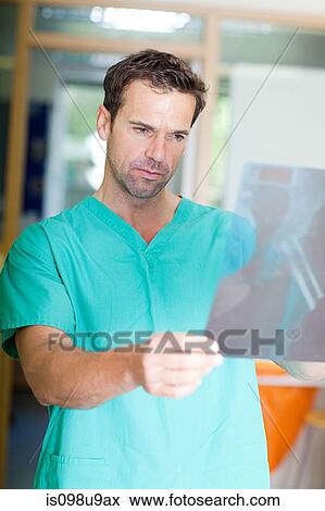 Male surgeon looking at xray View Large Photo Image Stock Photo - Male surgeon looking at xray. Fotosearch