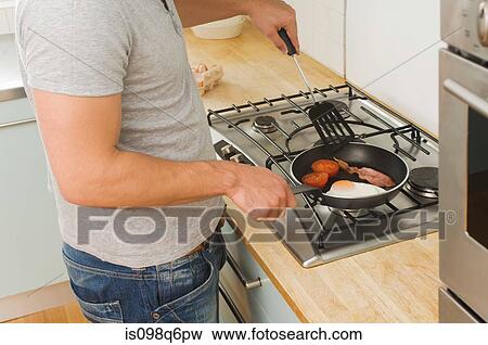 Man cooking fried breakfast View Large Photo Image Stock Photo - Man cooking fried breakfast. Fotosearch