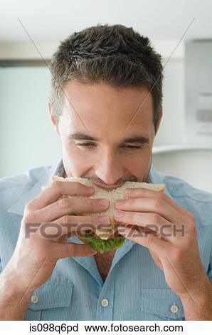 Stock Image - Man eating sandwich. Fotosearch