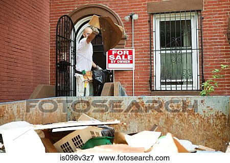 Man filling skip with rubble View Large Photo Image Stock Photo - Man filling skip with rubble. Fotosearch