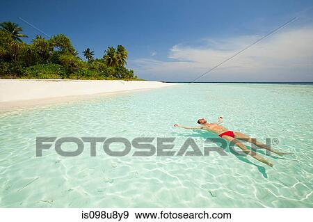 Man floating in sea, Baughagello Island, South Huvadhu Atoll, Maldives View Large Photo Image Stock Photo - Man floating in sea, Baughagello Island, South Huvadhu Atoll, Maldives. Fotosearch