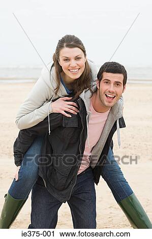 Man giving woman a piggyback View Large Photo Image Stock Image - Man giving woman a piggyback. Fotosearch