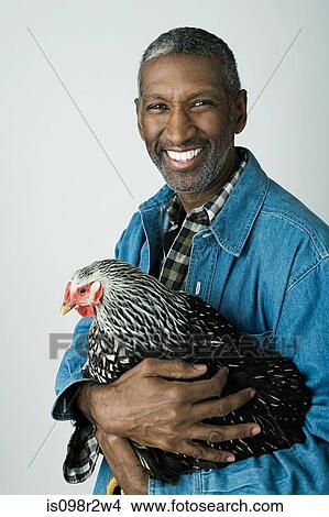 Picture - Man holding a chicken. Fotosearch