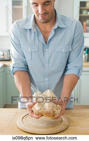 Picture - Man holding bread. Fotosearch