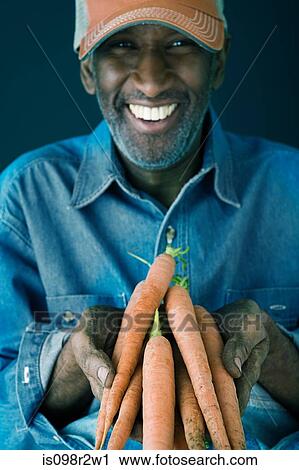Man holding carrots View Large Photo Image Stock Image - Man holding carrots. Fotosearch