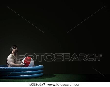 Man in a paddling pool with beach ball View Large Photo Image Stock Photo - Man in a paddling pool with beach ball. Fotosearch
