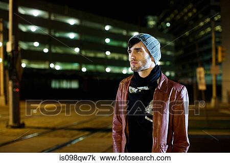 Stock Image - Man in city at night. Fotosearch