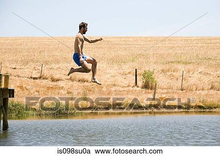 Stock Image - Man jumping into lake. Fotosearch