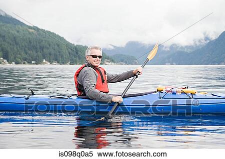 Stock Photography - Man kayaking in fjord. Fotosearch