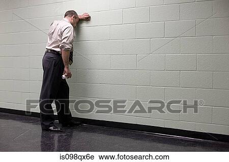 Stock Image - Man leaning against wall. Fotosearch