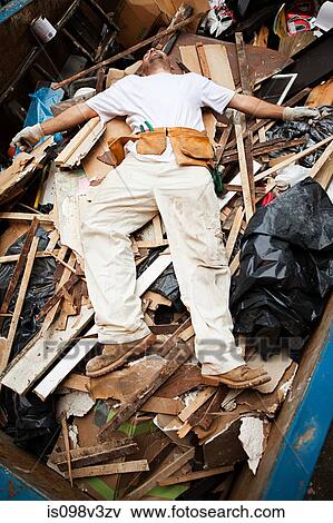 Man lying on top of pile of rubble in skip View Large Photo Image Stock Photo - Man lying on top of pile of rubble in skip. Fotosearch