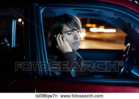 Picture - Man on cellphone in car. Fotosearch