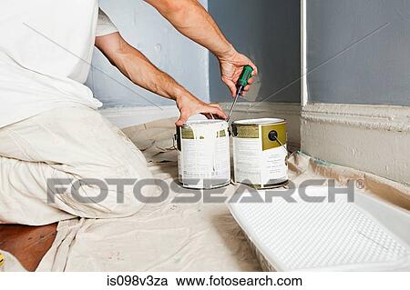 Stock Image - Man opening paint tin. Fotosearch