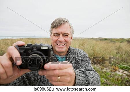 Man outdoors with camera View Large Photo Image Stock Photograph - Man outdoors with camera. Fotosearch