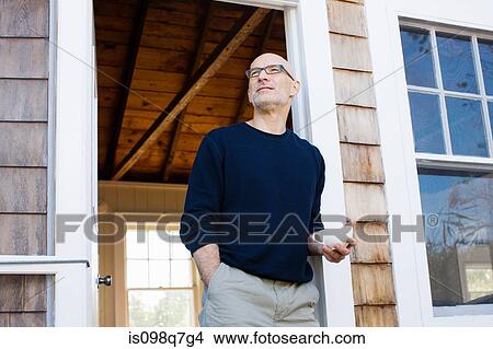 Picture - Man outside house. Fotosearch