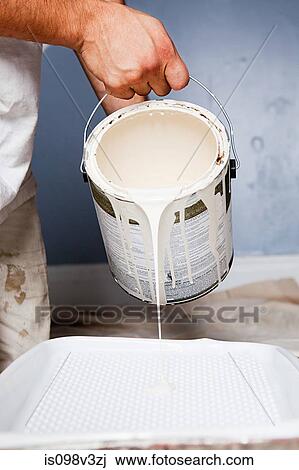 Stock Image - Man pouring paint. Fotosearch