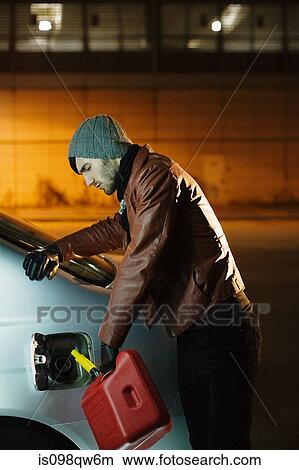 Picture - Man putting petrol in car. Fotosearch