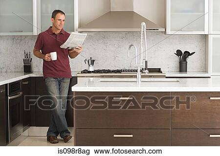 Man reading a newspaper in kitchen View Large Photo Image Stock Image - Man reading a newspaper in kitchen. Fotosearch