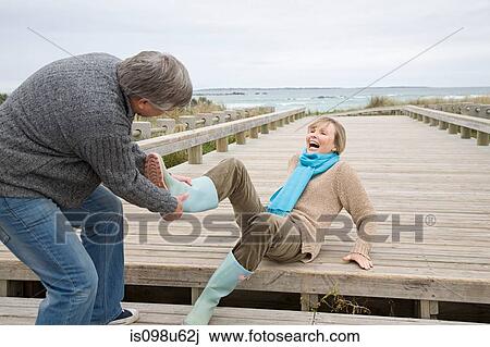 Man removing woman's rubber boot View Large Photo Image Stock Image - Man removing woman's rubber boot. Fotosearch