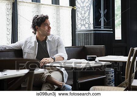 Stock Image - Man sitting in coffee shop. Fotosearch