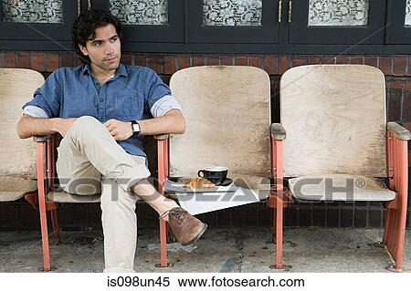 Stock Photography - Man sitting outside coffee shop. Fotosearch