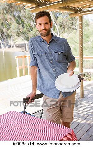 Picture - Man standing near table. Fotosearch