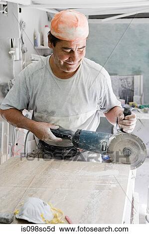 Stock Image - Man using circular saw. Fotosearch